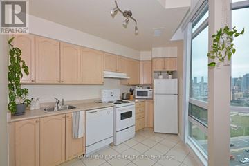 Toronto (Niagara) condo for rent - A kitchen with wooden cabinets and white appliances.