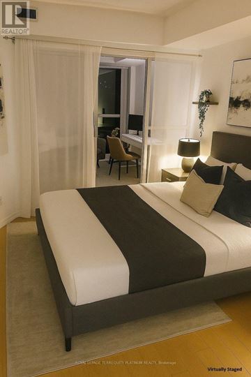 Toronto (Willowdale East) condo for rent - A bedroom with a large bed and a chair in the background.