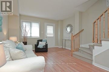 Pickering (Town Centre) townhouse for rent - A living room with a white couch and a wooden staircase.
