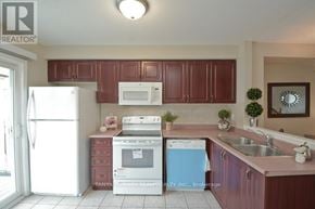 Pickering (Town Centre) townhouse for rent - A kitchen with brown cabinets and a white refrigerator.