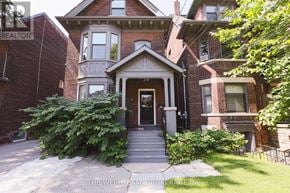 Toronto (North Riverdale) apartment for rent - A house with a front yard and a sign that says "The Weir Team: Brokerage Inc."