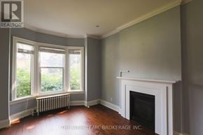 Toronto (North Riverdale) apartment for rent - A room with a fireplace and a window with a radiator.