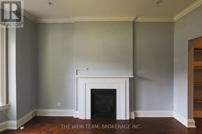Toronto (North Riverdale) apartment for rent - A room with a fireplace and a wall that is painted gray.