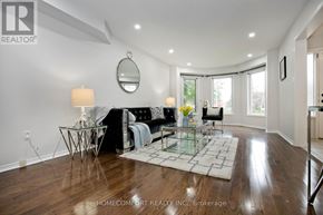Mississauga (Central Erin Mills) apartment for rent - A well-lit living room with a glass coffee table and a black couch.