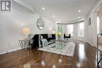 Mississauga (Central Erin Mills) apartment for rent - A well-lit living room with a glass coffee table and a black couch.