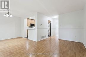 Mississauga (Erin Mills) townhouse for rent - A spacious room with wooden flooring and white walls.