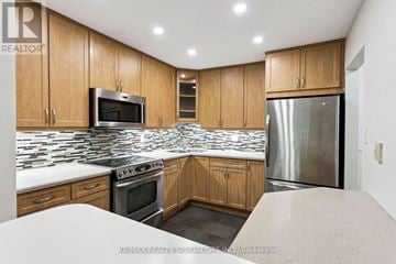 Mississauga (Erin Mills) townhouse for rent - A kitchen with wooden cabinets and a stainless steel refrigerator.