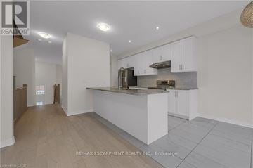 Lincoln (Beamsville) townhouse for rent - A modern kitchen with white cabinets and a central island.