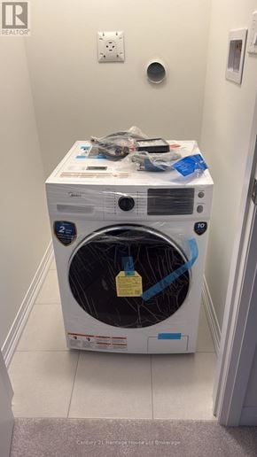 Woodstock (Woodstock - South) townhouse for rent - A white dryer with a yellow tag on the door sits in a small room.