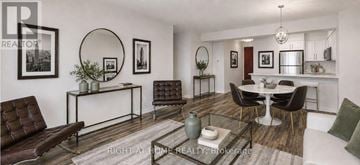 Toronto (Bay Street Corridor) condo for rent - A living room with a brown leather couch and a glass coffee table.