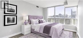 Toronto (Bay Street Corridor) condo for rent - A bedroom with a purple bed and a window overlooking a cityscape.
