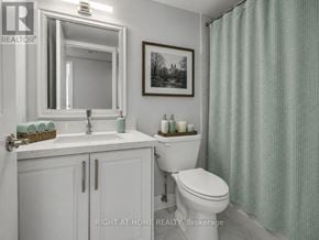 Toronto (Bay Street Corridor) condo for rent - A bathroom with a toilet, sink, and shower curtain.