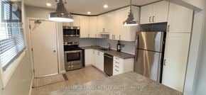 Guelph (St. George's) apartment for rent - A kitchen with white cabinets and a stainless steel refrigerator.