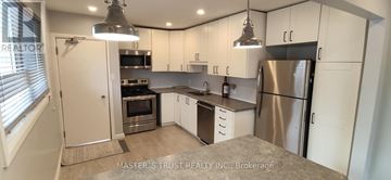 Guelph (St. George's) apartment for rent - A kitchen with white cabinets and a stainless steel refrigerator.