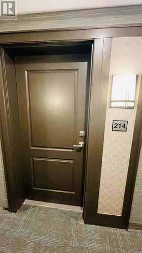 Hamilton (Waterdown) condo for rent - A brown door with a number 214 on the wall next to it.