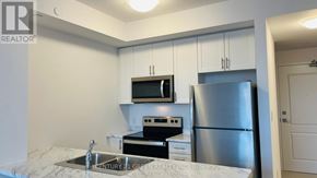 Hamilton (Waterdown) condo for rent - A kitchen with white cabinets and a stainless steel refrigerator.