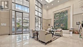 Toronto (Willowdale East) condo for rent - A spacious lobby with a large painting, a dining table and chairs, and a reception desk.
