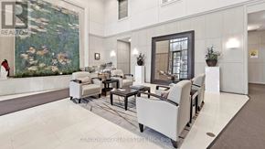Toronto (Willowdale East) condo for rent - A living room with a large painting on the wall and a woman standing in the background.