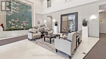 Toronto (Willowdale East) condo for rent - A living room with a large painting on the wall and a woman standing in the background.