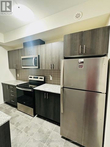 Toronto (Malvern) townhouse for rent - A kitchen with a stainless steel refrigerator and a microwave above the stove.