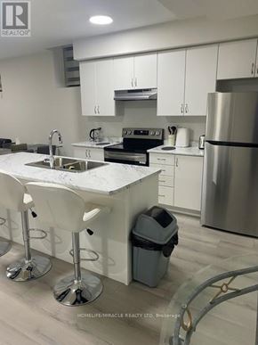 Bradford West Gwillimbury (Bond Head) apartment for rent - A modern kitchen with white cabinets and a marble countertop.