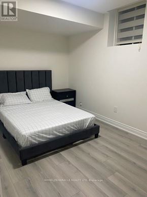 Bradford West Gwillimbury (Bond Head) apartment for rent - A bedroom with a bed, nightstand, and window.