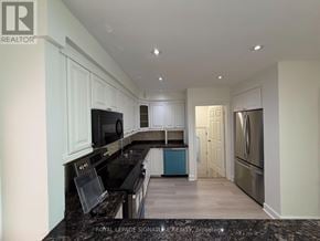 Mississauga (Mississauga Valleys) apartment for rent - A kitchen with black countertops and white cabinets.