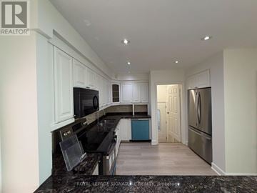 Mississauga (Mississauga Valleys) apartment for rent - A kitchen with black countertops and white cabinets.