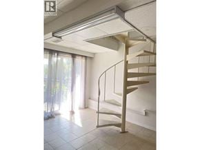 Burnaby apartment for rent - A spiral staircase in a room with a window.