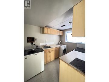 Burnaby apartment for rent - A kitchen with a white dishwasher and a black stove top.