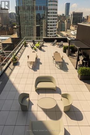 Toronto (Church-Yonge Corridor) condo for rent - A patio with chairs and tables overlooking a city.