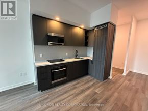 Vaughan (Vaughan Corporate Centre) condo for rent - A modern kitchen with dark wood cabinets and stainless steel appliances.
