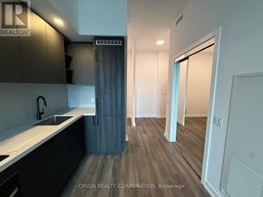 Vaughan (Vaughan Corporate Centre) condo for rent - A modern kitchen with dark wood floors and white countertops.