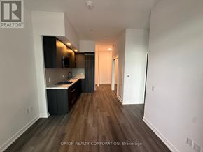 Vaughan (Vaughan Corporate Centre) condo for rent - A kitchen with dark wood floors and white walls.