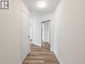 Toronto (Mimico) condo for rent - A hallway with a door on the right and a wall on the left.