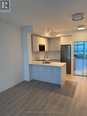 Mississauga (Central Erin Mills) condo for rent - A modern kitchen with a sink, stove, and refrigerator.