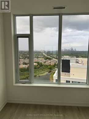 Mississauga (Central Erin Mills) condo for rent - A window with a view of a cityscape and greenery outside.
