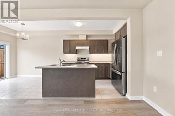 Fort Erie (Crescent Park) townhouse for rent - A modern kitchen with a stainless steel refrigerator and a central island.