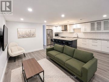 St. Catharines (Lakeport) apartment for rent - A living room with a green couch, a chair, and a coffee table.