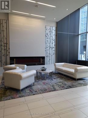 Toronto (Lansing-Westgate) condo for rent - A white sofa and chair are in a room with a patterned carpet.