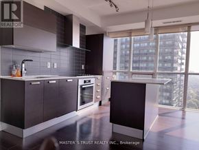 Toronto (Lansing-Westgate) condo for rent - A modern kitchen with dark brown cabinets and a large window.