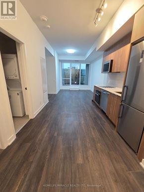 Toronto (Clairlea-Birchmount) condo for rent - A spacious kitchen with wooden floors and modern appliances.