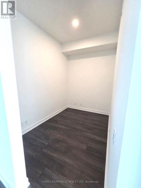 Toronto (Clairlea-Birchmount) condo for rent - A room with white walls and dark wood flooring.