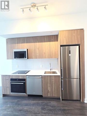 Toronto (Clairlea-Birchmount) condo for rent - A kitchen with wooden cabinets and stainless steel appliances.