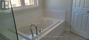 Georgina (Keswick North) apartment for rent - A white bathtub with a silver faucet is in a bathroom with a white door.