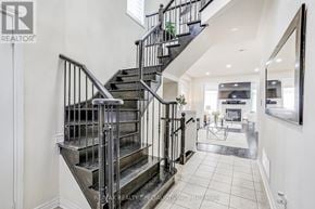 Bradford West Gwillimbury (Bradford) apartment for rent - A staircase with a metal railing and a glass balustrade leads to a living room.