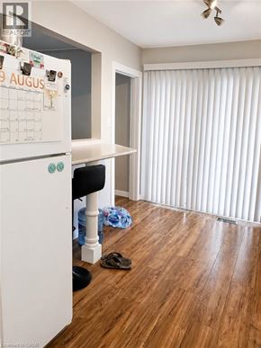 Kitchener apartment for rent - A kitchen with a calendar on the fridge and a wooden floor.