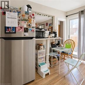 Kitchener apartment for rent - A small kitchen with a refrigerator covered in magnets and a table with chairs.