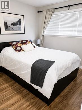 Kitchener apartment for rent - A bedroom with a white bed and a picture on the wall.