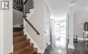 Clarington (Courtice) apartment for rent - A hallway with a staircase and a television on the wall.